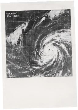 A black and white satellite photograph of a spiralling weather system.